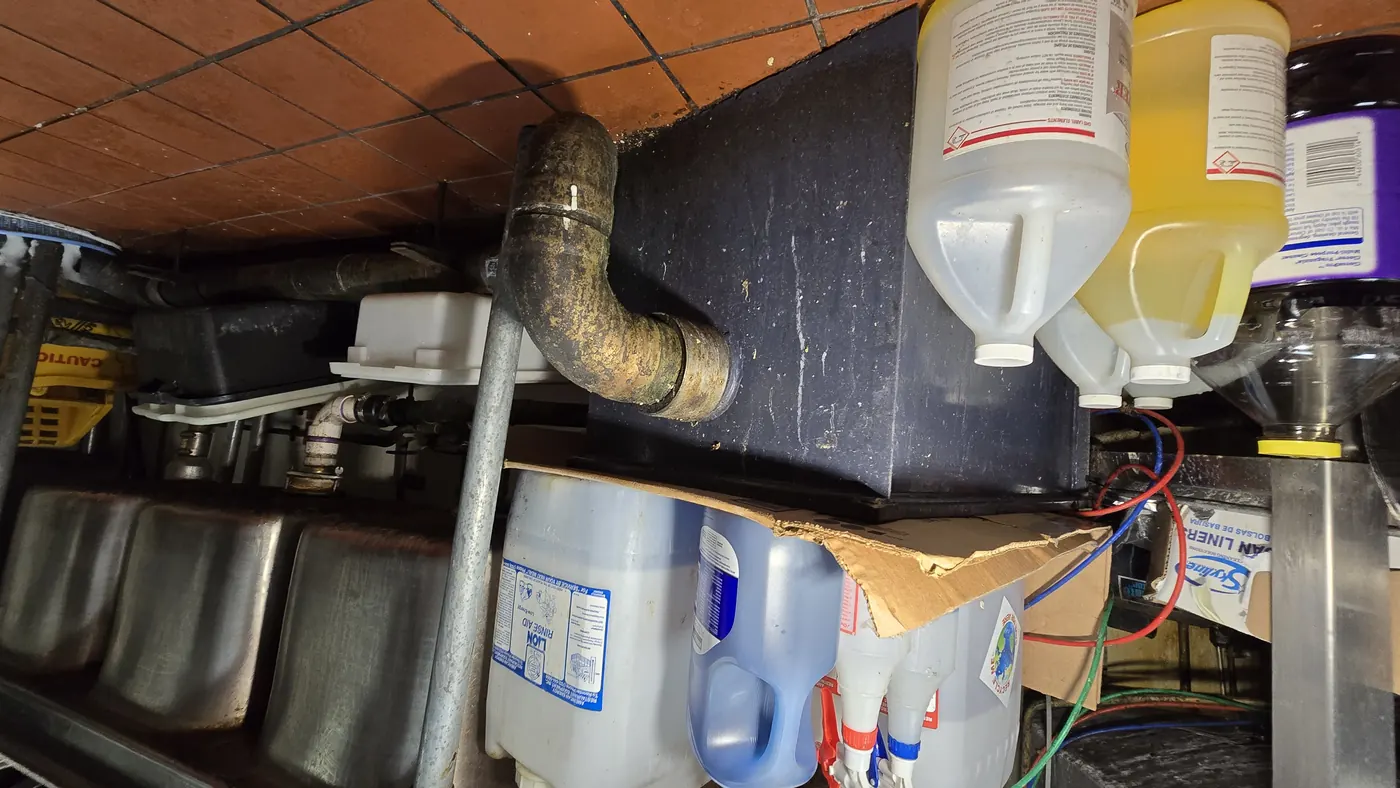 A grease receptor installed above floor level with associated waste pipework