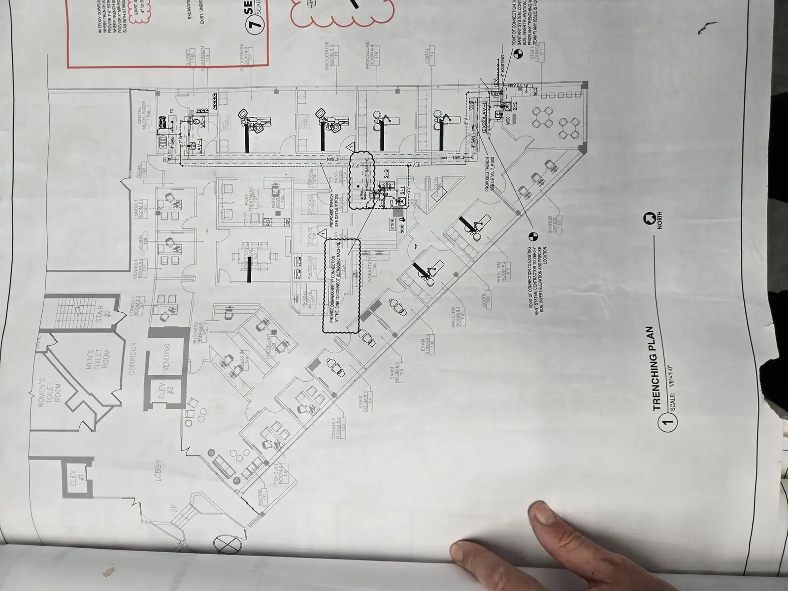 Construction bid drawings being read on a desk during a quantity take-off and estimate
