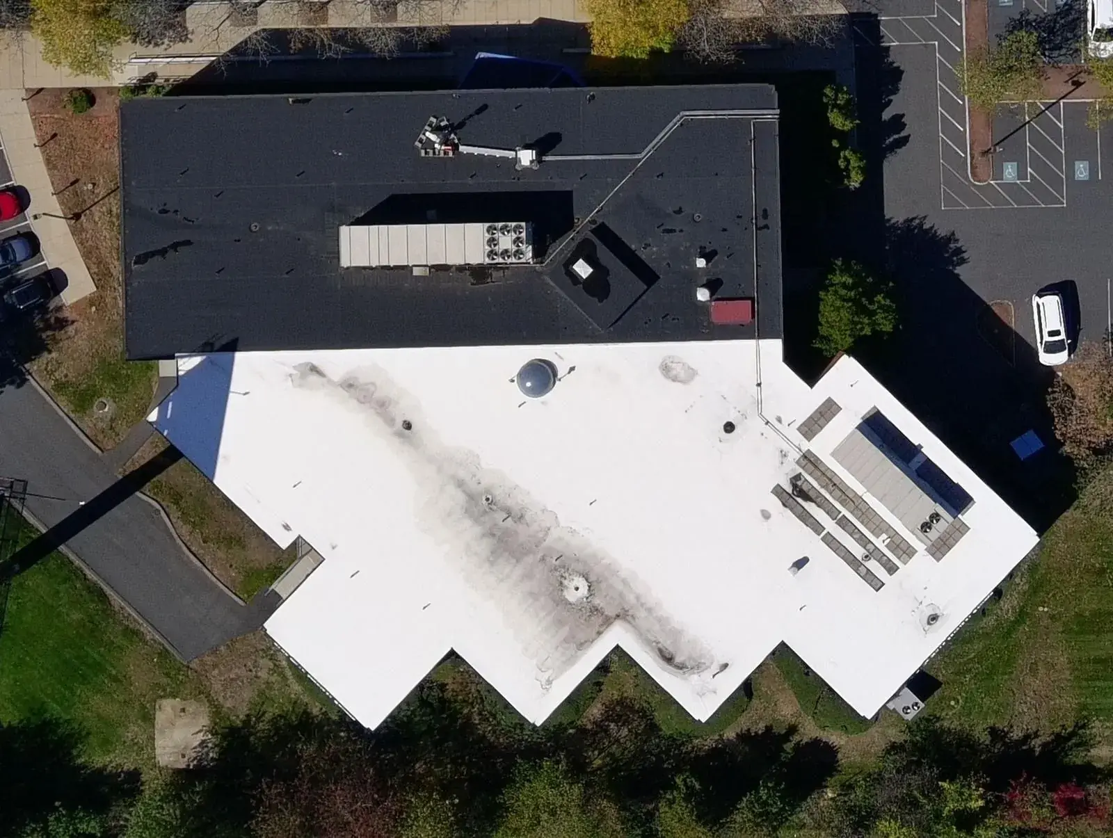 Aerial orthographic survey of a commercial building roof, showing plant, membrane condition and the surrounding site