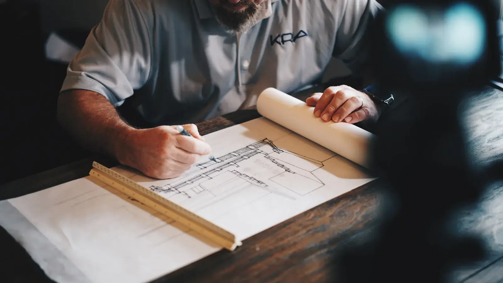 Architectural blueprints and technical drawings on a desk with building structure visible